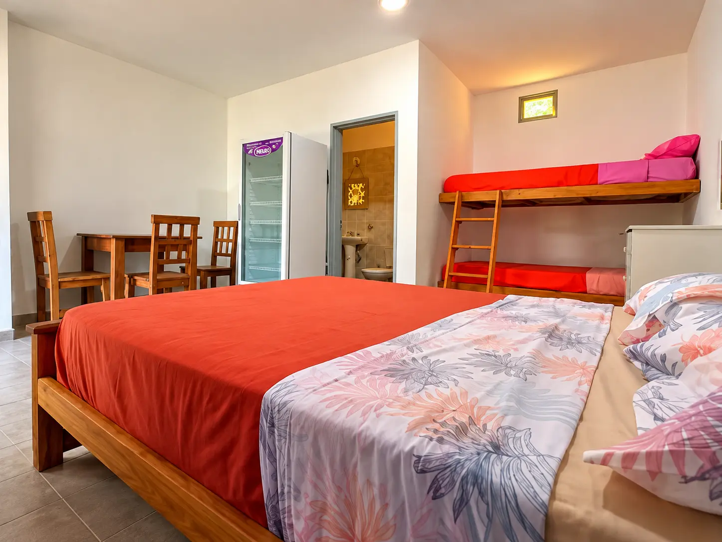 Interior de la habitación con cama, cucheta y mesa