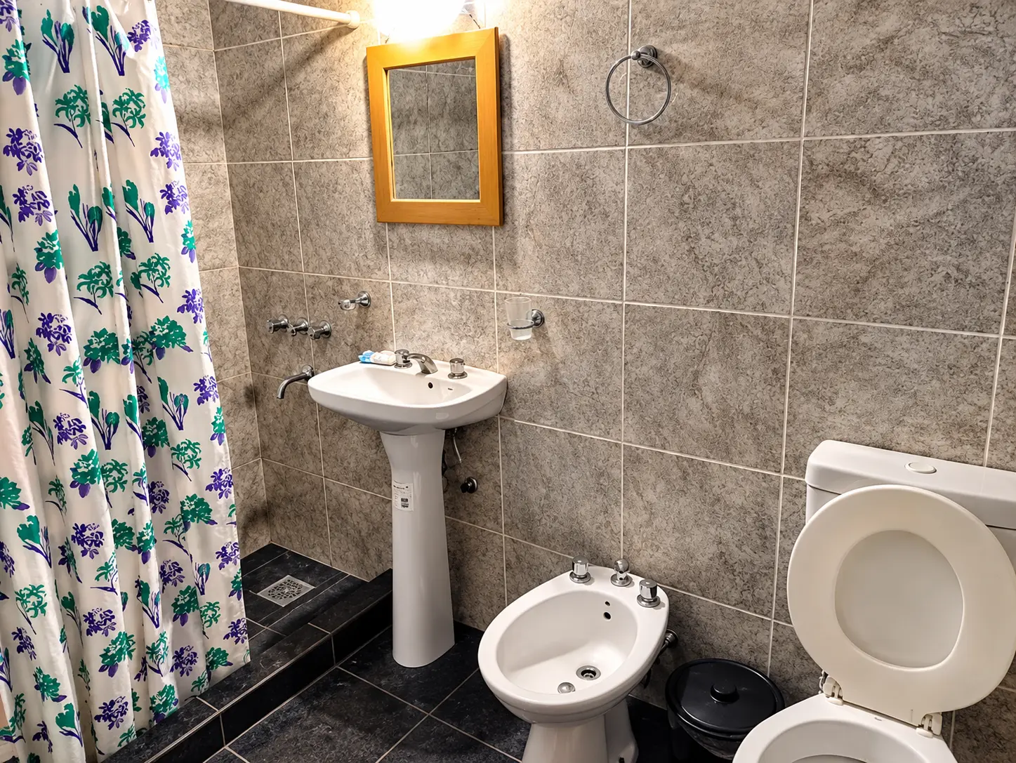 Baño con ducha, lavamanos y espejo
